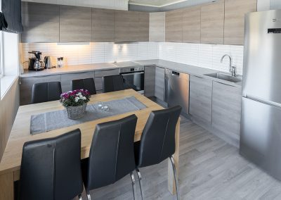 Kitchen/dining area with a table, chairs, and an open-plan kitchen.