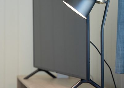 Close-up of a table lamp on a bedside table by the wall.