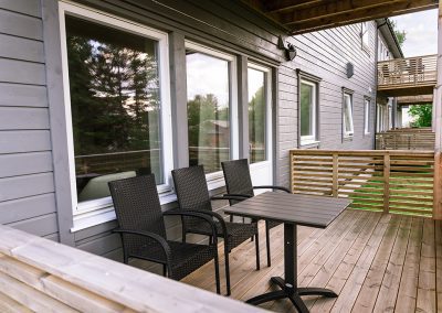 Terrace with outdoor furniture and sliding doors leading into the cabin.